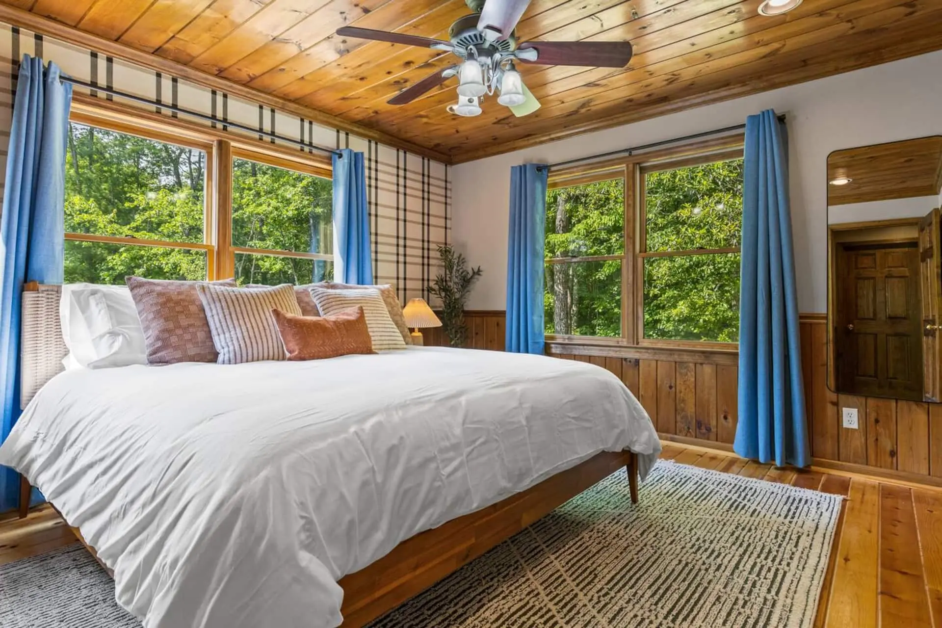 Large, open bedroom with king bed.  Windows on all sides allows you to sleep with nature!