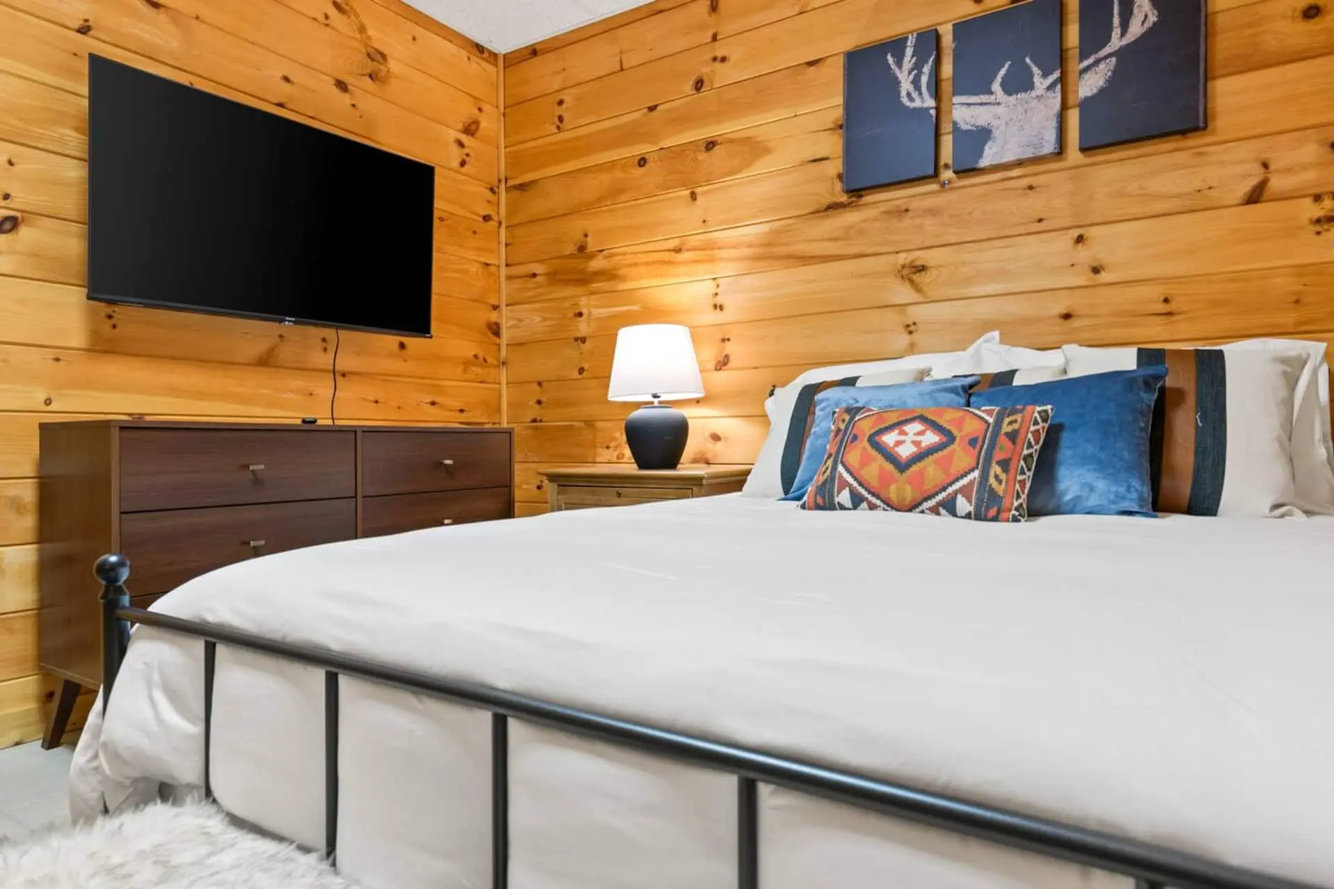 A quiet and cozy bedroom featuring a comfortable queen bed, warm wood walls, and soft lighting—perfect for a restful night’s sleep. This peaceful retreat offers a calm, private space to unwind after a day of exploring.