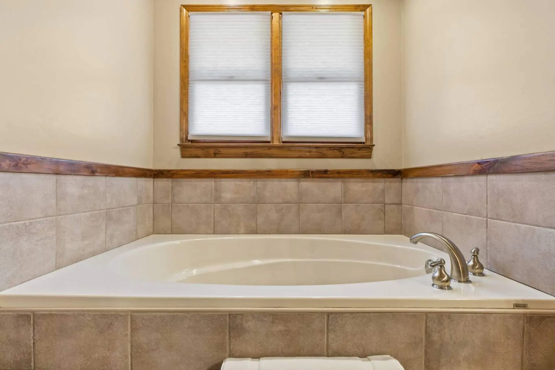 Unwind in the spacious soaking tub—perfect for relaxing after a day of hiking or exploring. Surrounded by warm tile accents and natural light from the window, this peaceful space invites you to slow down and recharge.