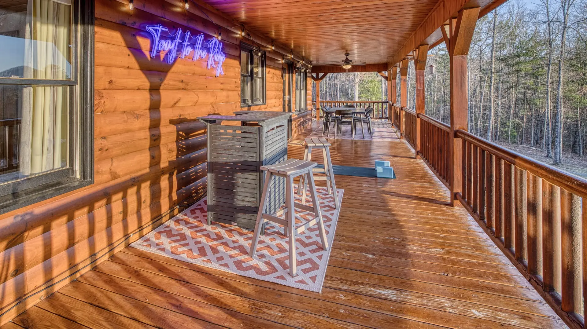 Spacious covered deck with bar, dining, ceiling fans & forest views
