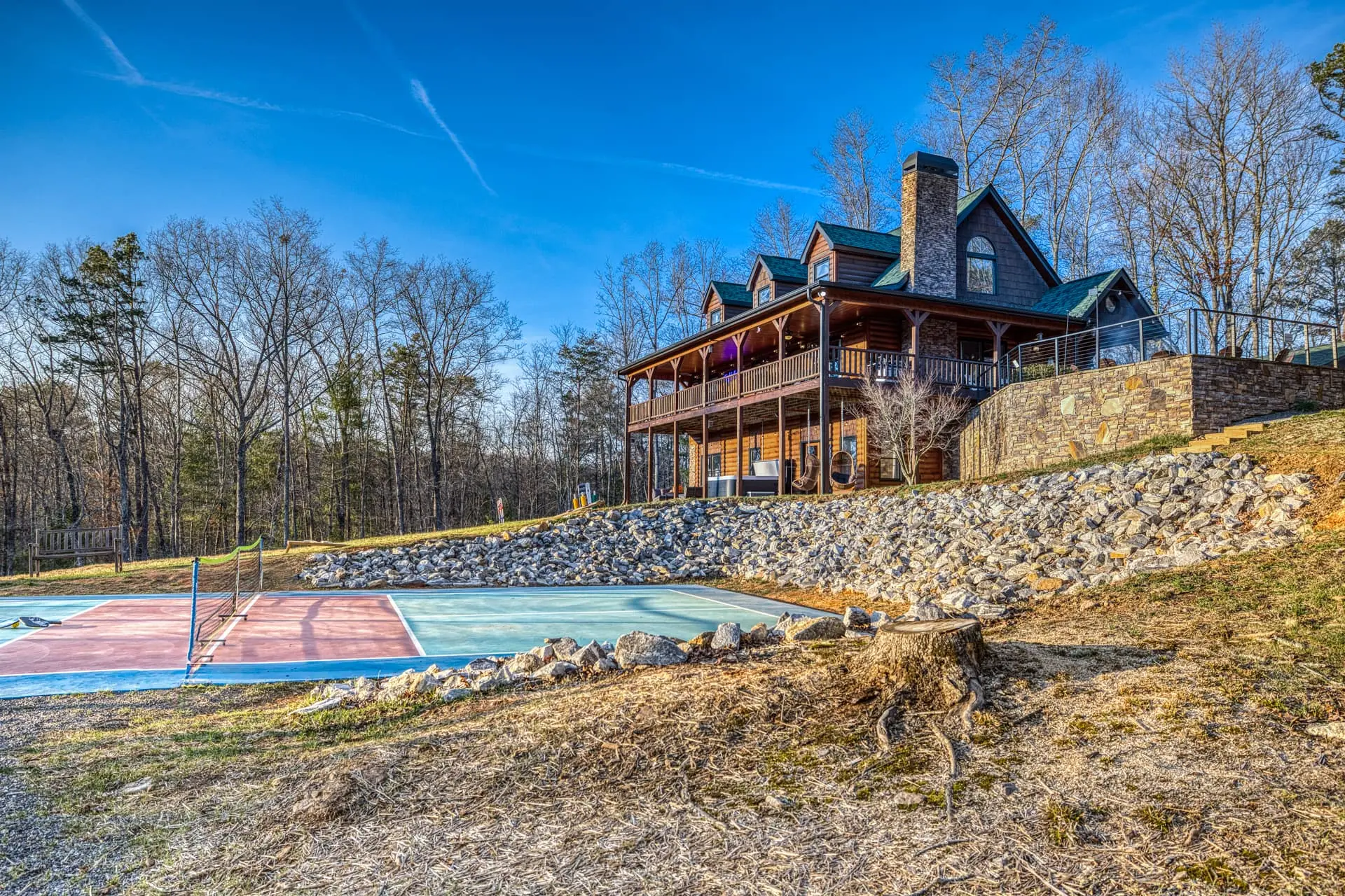 Rustic lodge with sport court, wraparound porch and wooded views