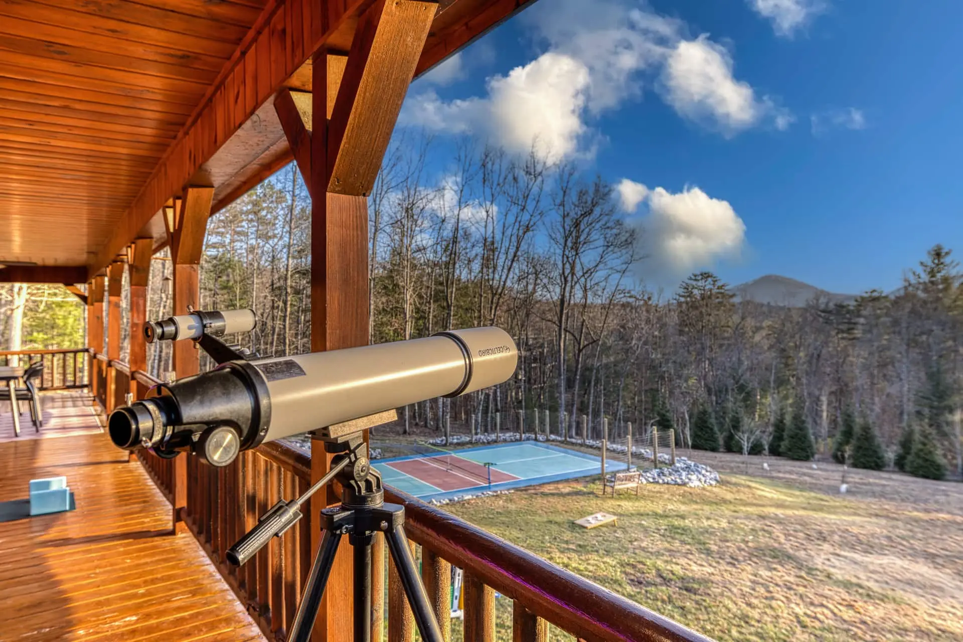 Covered porch with telescope for mountain viewing and stargazing. Enjoy peaceful forest views overlooking the private pickleball court—perfect for morning coffee, sunset watching, or spotting wildlife in the surrounding Blue Ridge landscape.