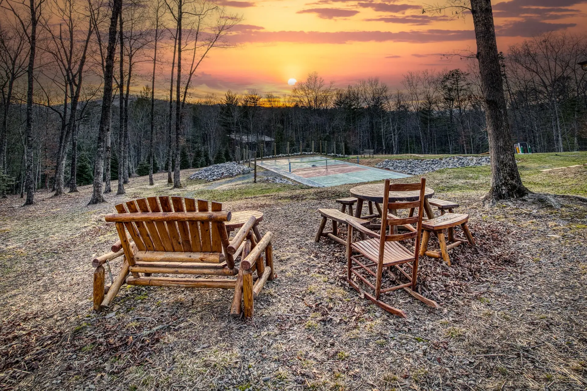 Rustic seating at sunset with forest views and private sport court